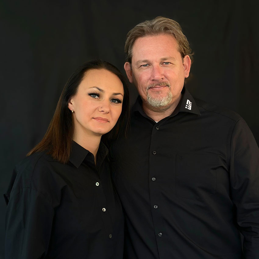 Patrizia Rausch und Wilbert Rausch, Geschäftsführung bei W. Rausch, auf einem gemeinsamen Porträtbild vor schwarzem Hintergrund